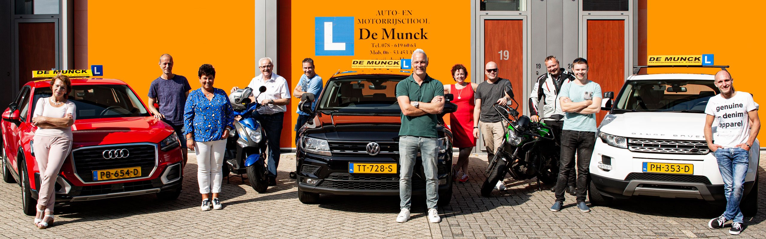 De medewerkers van Autorijschool De Munck buiten tussen de leswagens en motoren